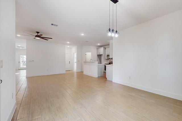 unfurnished living room with light wood finished floors, visible vents, baseboards, recessed lighting, and a ceiling fan