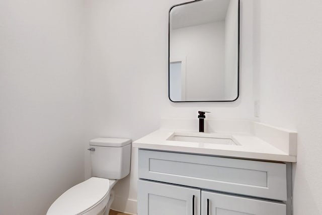 half bathroom with toilet and vanity