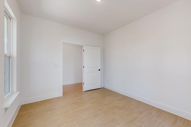 spare room with light wood-style floors and baseboards