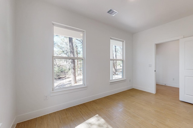 spare room with light wood-style flooring, baseboards, and visible vents