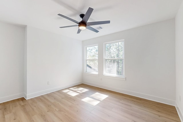 spare room featuring visible vents, a ceiling fan, light wood-type flooring, and baseboards