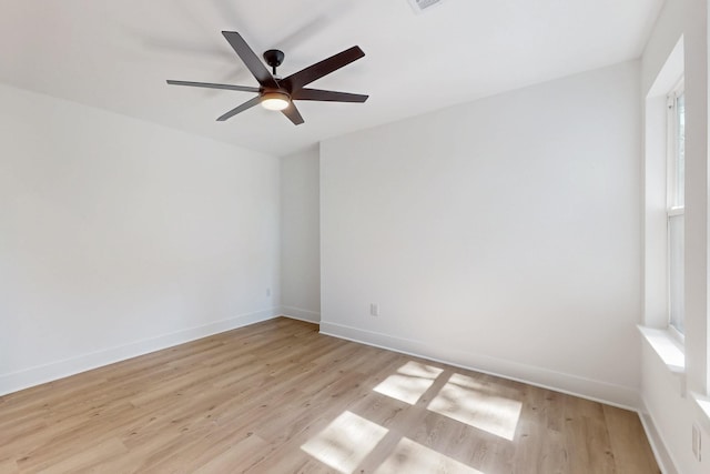 unfurnished room featuring baseboards, plenty of natural light, light wood-style flooring, and a ceiling fan