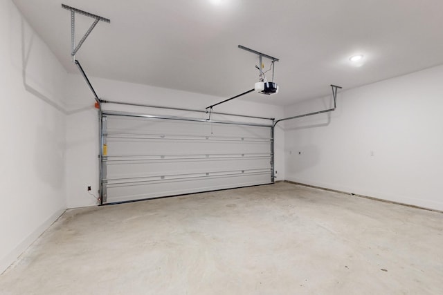 garage featuring a garage door opener and baseboards