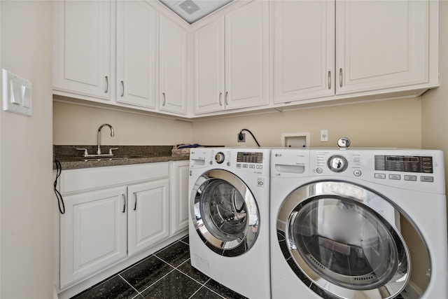 laundry room featuring washing machine and dryer, cabinet space, and a sink