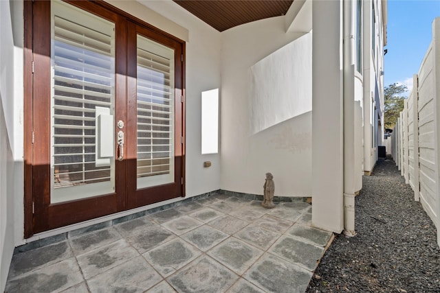 entrance to property with a patio area, french doors, and fence