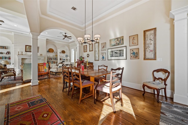 dining room featuring dark wood finished floors, built in features, decorative columns, arched walkways, and a ceiling fan