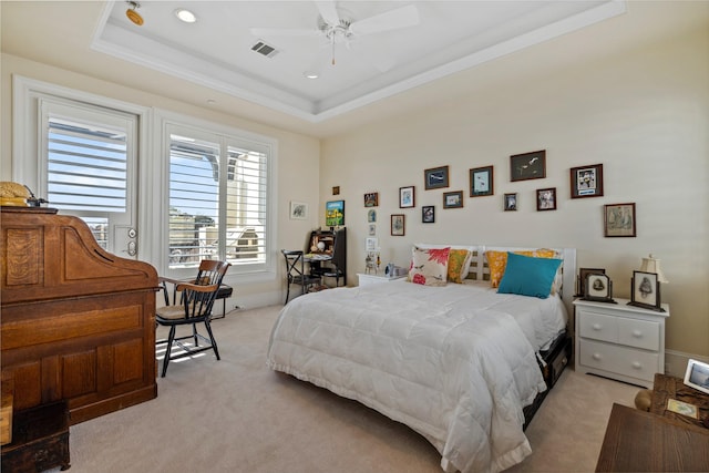 bedroom featuring light carpet, visible vents, and a raised ceiling