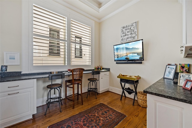 office area with baseboards, wood finished floors, ornamental molding, and built in study area