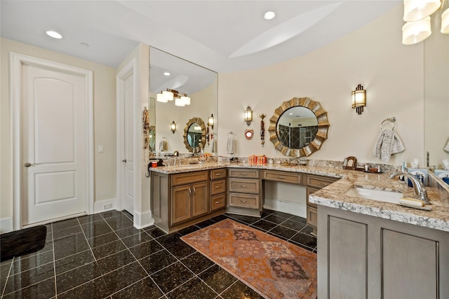 bathroom featuring baseboards, double vanity, granite finish floor, recessed lighting, and a sink