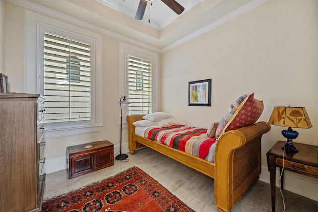 bedroom featuring ceiling fan, baseboards, crown molding, and a tray ceiling