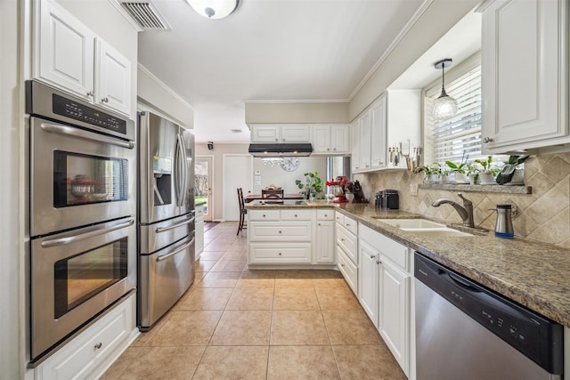 kitchen with white cabinets, light tile patterned flooring, appliances with stainless steel finishes, and a sink