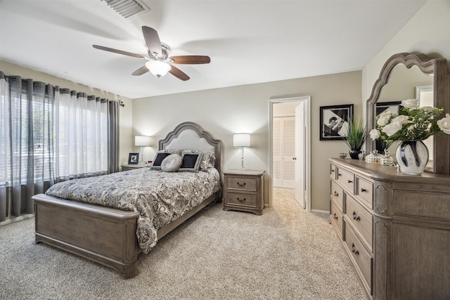 bedroom with visible vents, light carpet, and a ceiling fan