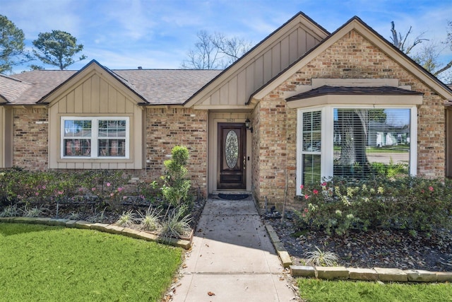 view of front of house with board and batten siding, brick siding, and a shingled roof