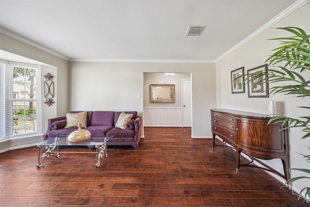 living room with visible vents, crown molding, and wood finished floors