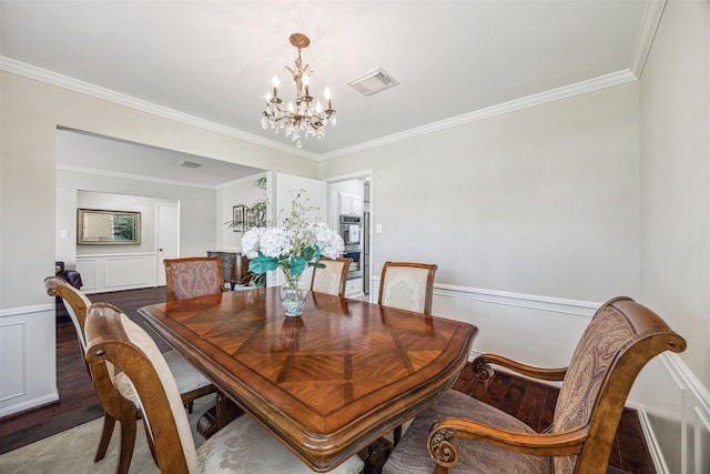 dining area with a wainscoted wall, visible vents, an inviting chandelier, and wood finished floors