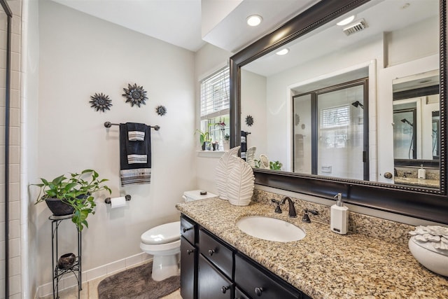 bathroom featuring visible vents, toilet, a tile shower, baseboards, and vanity