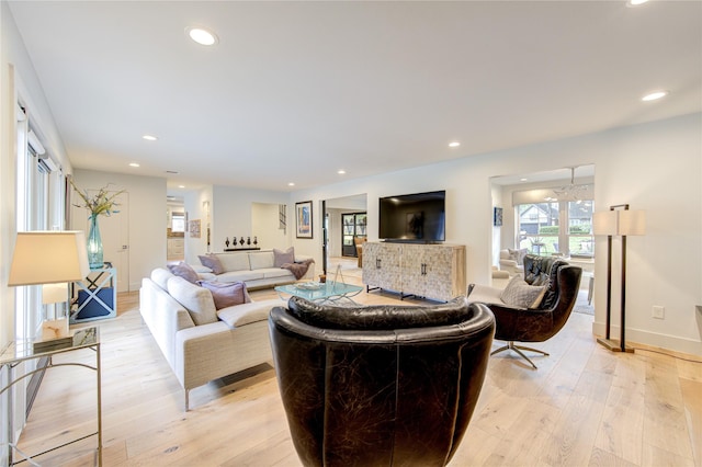 living area featuring recessed lighting, baseboards, and light wood-style floors