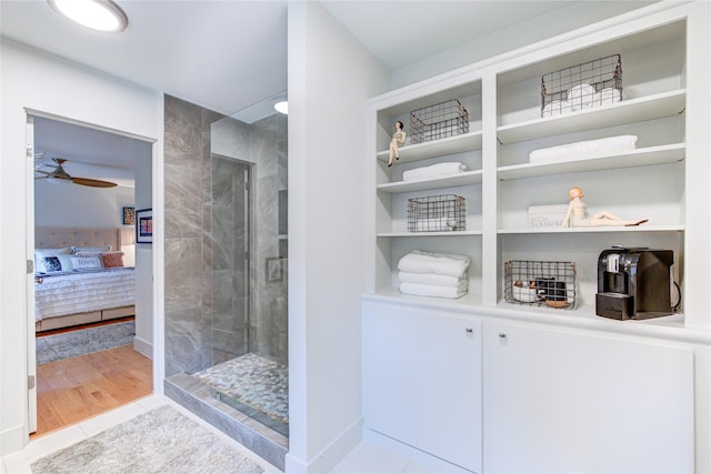 ensuite bathroom with a ceiling fan, walk in shower, wood finished floors, and ensuite bathroom