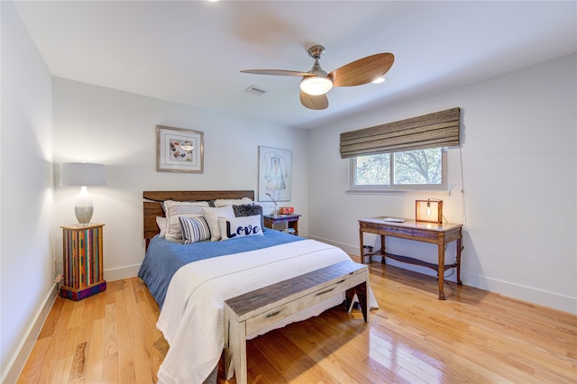 bedroom with visible vents, baseboards, light wood-style floors, and a ceiling fan