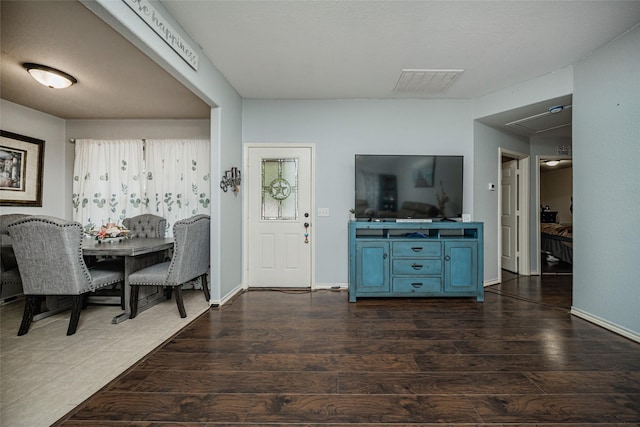 dining room with visible vents, attic access, baseboards, and dark wood-style flooring