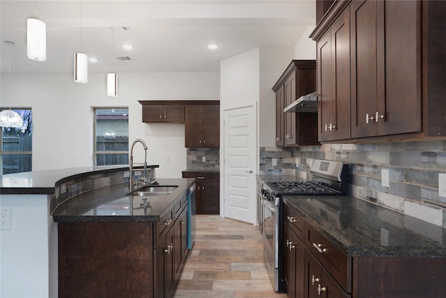 kitchen featuring visible vents, a sink, under cabinet range hood, dark brown cabinetry, and appliances with stainless steel finishes