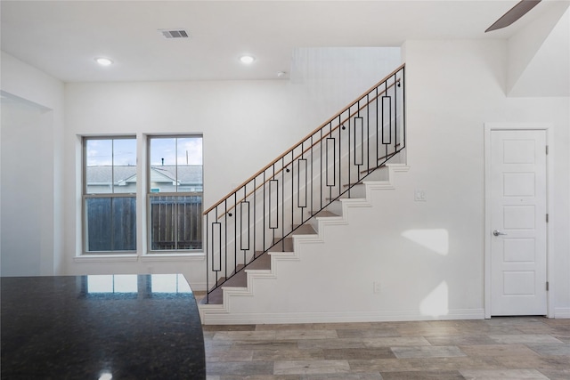 stairway featuring recessed lighting, visible vents, baseboards, and wood finished floors