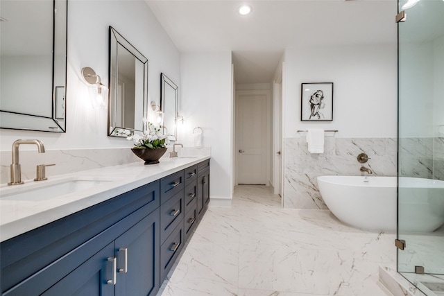 full bath featuring double vanity, a freestanding tub, marble finish floor, and a sink