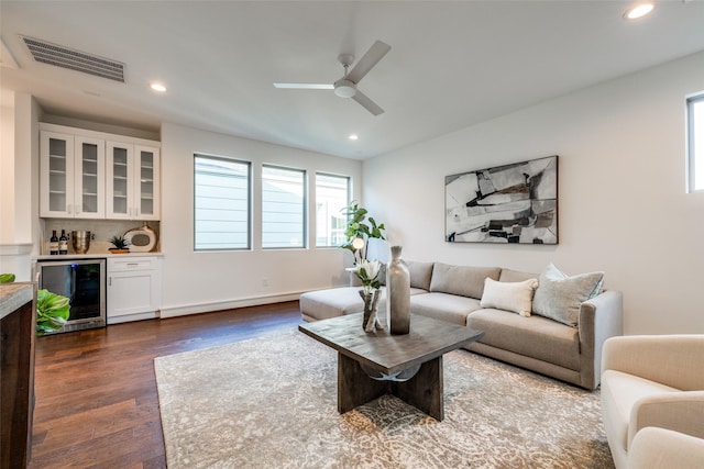 living room with visible vents, plenty of natural light, beverage cooler, and dark wood finished floors