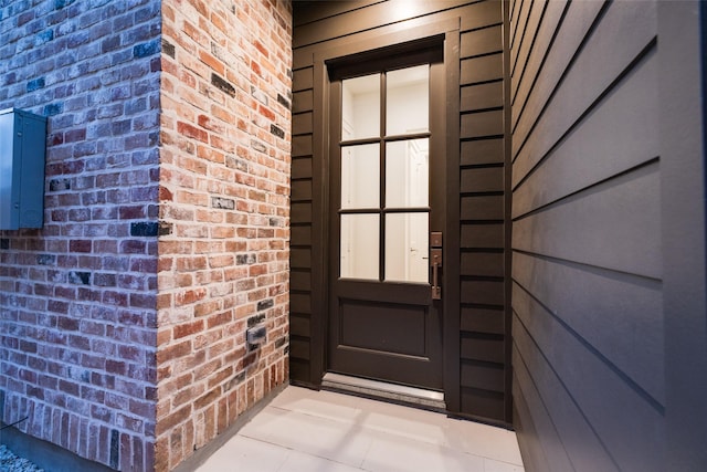 view of exterior entry with brick siding