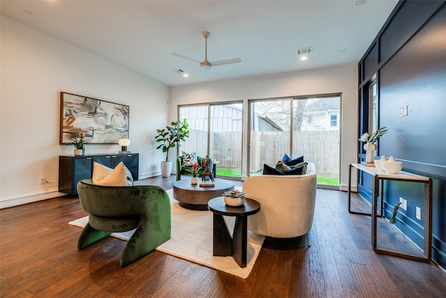 living room featuring wood finished floors, visible vents, and baseboards