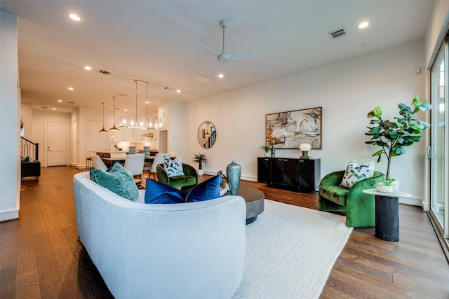 living area with recessed lighting, visible vents, wood finished floors, and stairway