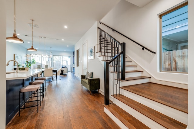 stairs with hardwood / wood-style flooring, recessed lighting, visible vents, and baseboards