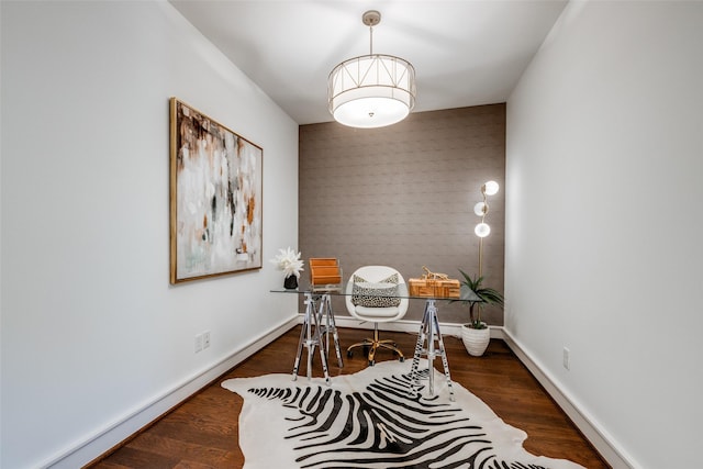 office space featuring an accent wall, baseboards, and wood finished floors