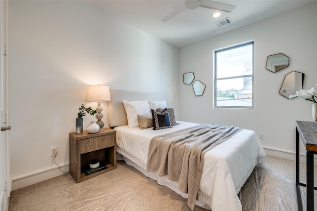 bedroom featuring baseboards, light colored carpet, visible vents, and ceiling fan