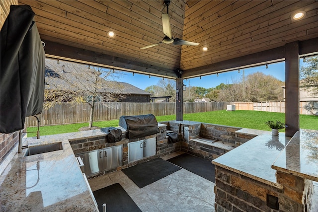 view of patio / terrace featuring area for grilling, a fenced backyard, and a sink