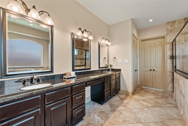 full bathroom with double vanity, tile patterned floors, a stall shower, and a sink