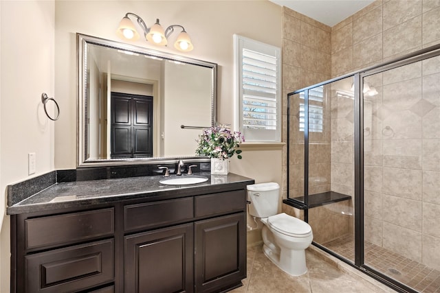 full bathroom featuring tile patterned floors, vanity, toilet, and a shower stall