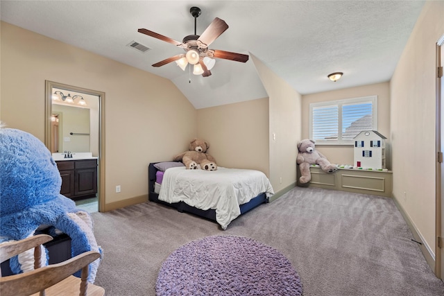 carpeted bedroom with visible vents, connected bathroom, baseboards, vaulted ceiling, and a ceiling fan