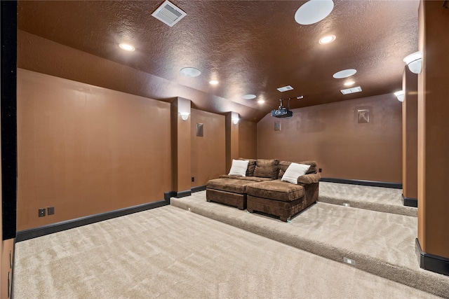 carpeted home theater featuring visible vents, lofted ceiling, a textured ceiling, and baseboards