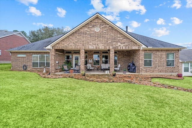 back of property with a patio, a lawn, brick siding, and roof with shingles