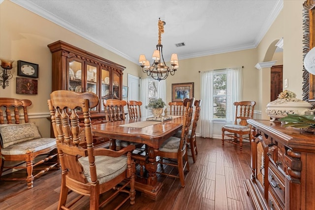 dining room featuring dark wood-type flooring, a notable chandelier, visible vents, and ornamental molding