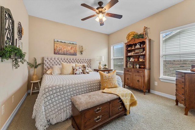 bedroom featuring multiple windows, light colored carpet, and baseboards