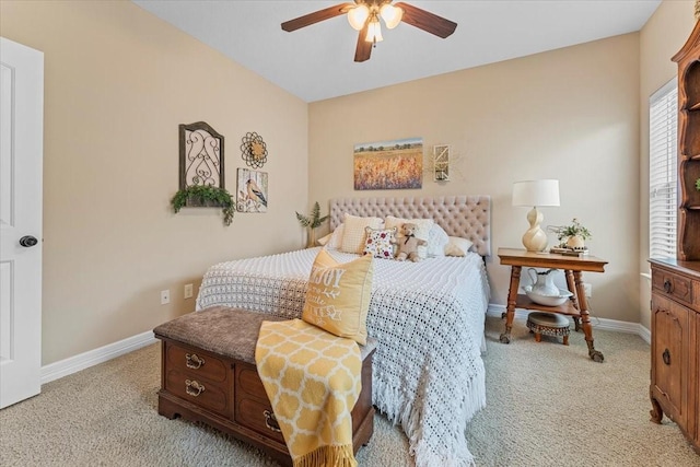 bedroom featuring baseboards, light colored carpet, and ceiling fan