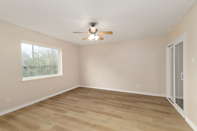 empty room featuring baseboards, light wood-style floors, and ceiling fan