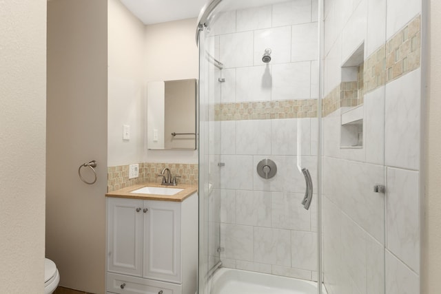 full bathroom with tasteful backsplash, a shower stall, toilet, and vanity