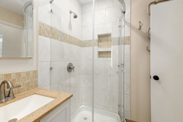 full bath with backsplash, a stall shower, and vanity