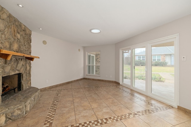 unfurnished living room with recessed lighting, light tile patterned floors, a fireplace, and baseboards