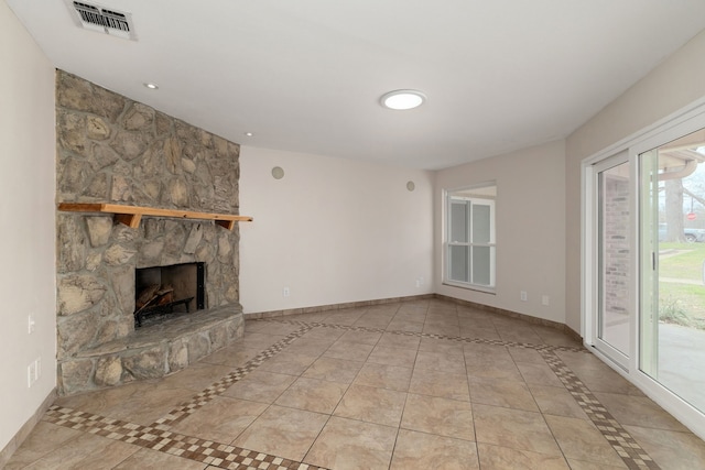 unfurnished living room featuring a fireplace, tile patterned floors, visible vents, and baseboards