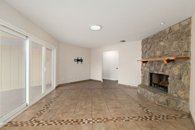 unfurnished living room featuring visible vents, baseboards, recessed lighting, a stone fireplace, and tile patterned floors