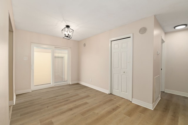 unfurnished dining area featuring visible vents, baseboards, light wood-style floors, and a chandelier